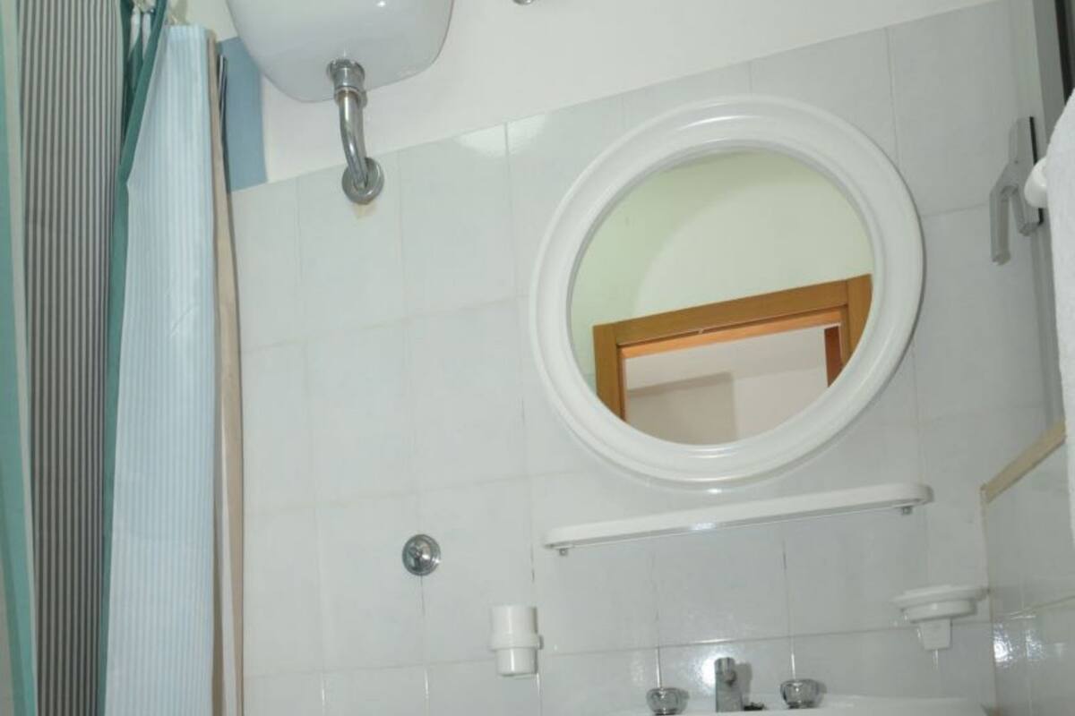 Un baño con inodoro, lavamanos y espejo.