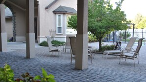 A covered outdoor seating area with lounge chairs and a stone pillar. - Perfect Moments B&B and Event Venue (Nampa)
