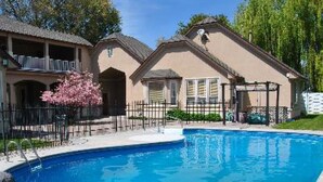 A residential property with a swimming pool, a covered patio, and a two-story house with a balcony. - Perfect Moments B&B and Event Venue (Nampa)