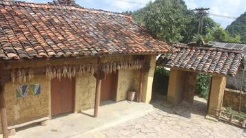 A traditional house with a tiled roof and a thatched roof structure.