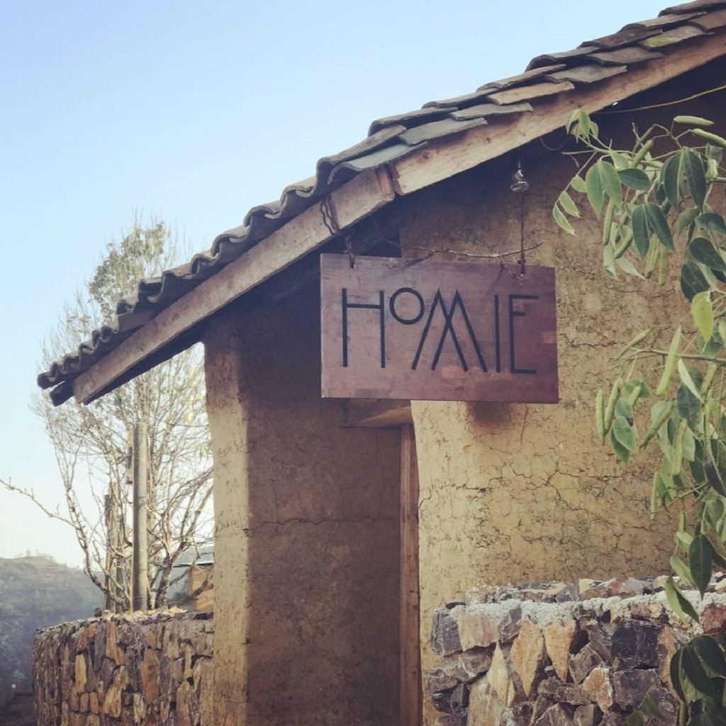 Un edificio rústico con fachada desgastada y un letrero que dice “HOME”.