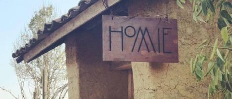 Un edificio rústico con fachada desgastada y un letrero que dice “HOME”.