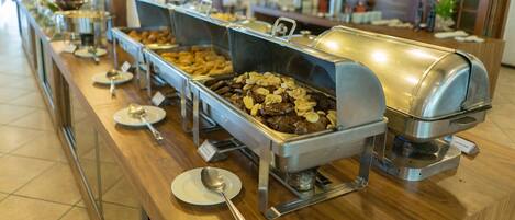 A buffet with various food stations, including a grill and a salad bar.