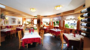 Un restaurante con interiores de madera, varias mesas para comer y una bodega de vinos.