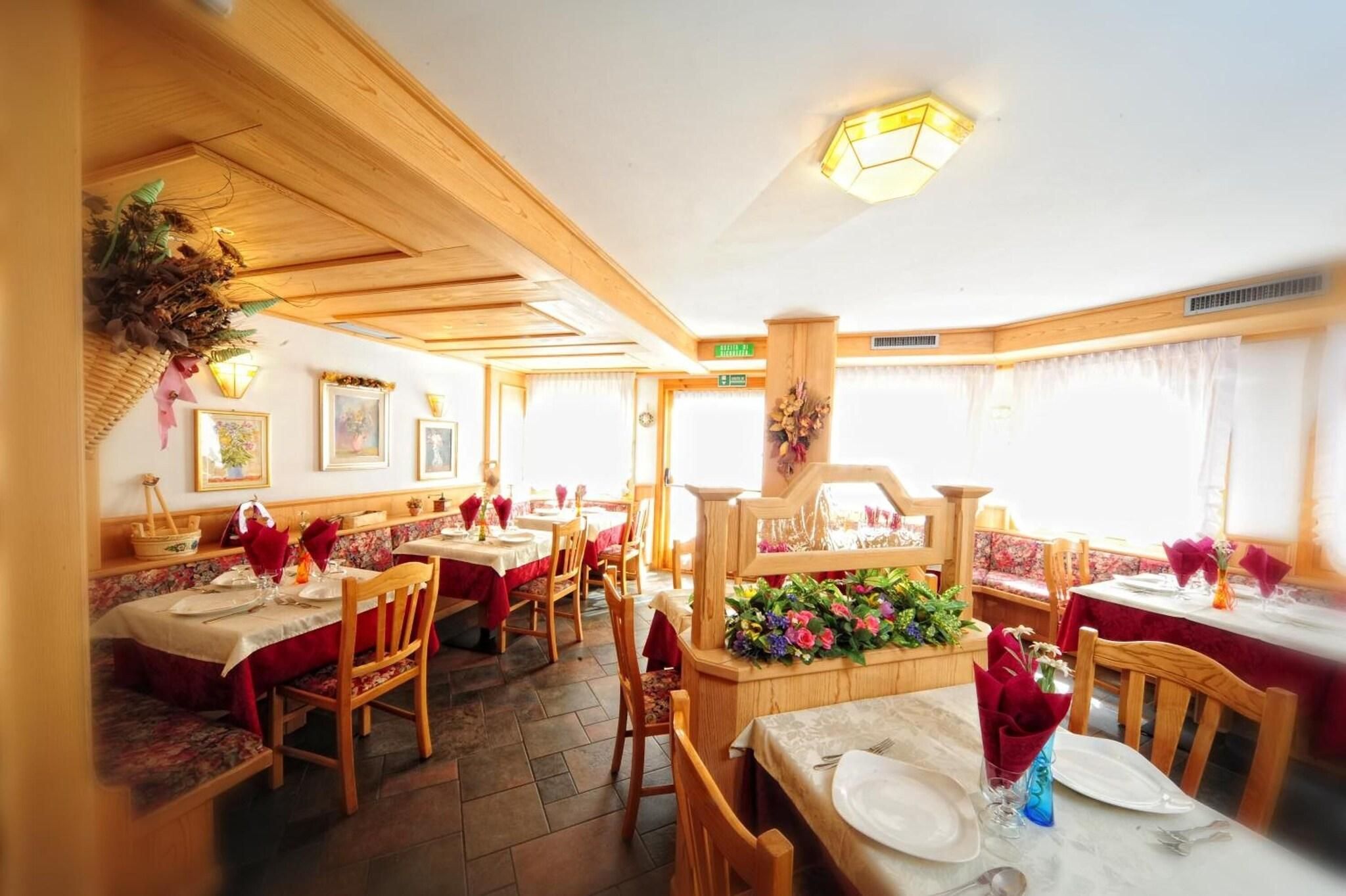 Ein Restaurant mit Holzeinrichtung, mehreren Tischen und Stühlen.