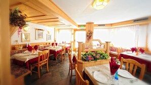 Ein Restaurant mit Holzeinrichtung, mehreren Tischen und Stühlen.