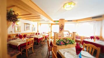 Ein Restaurant mit Holzeinrichtung, mehreren Tischen und Stühlen.