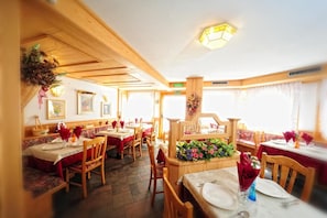 Un restaurante con interiores de madera, varias mesas y sillas.