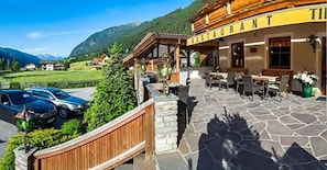 Un restaurant doté d’une terrasse, d’un sol en pierre et offrant une vue sur les montagnes.