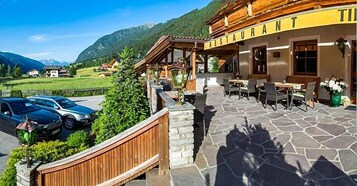 Un restaurant doté d’une terrasse, d’un sol en pierre et offrant une vue sur les montagnes.