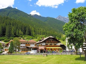 Un hôtel situé au pied d’une montagne, doté d’un restaurant avec une terrasse.