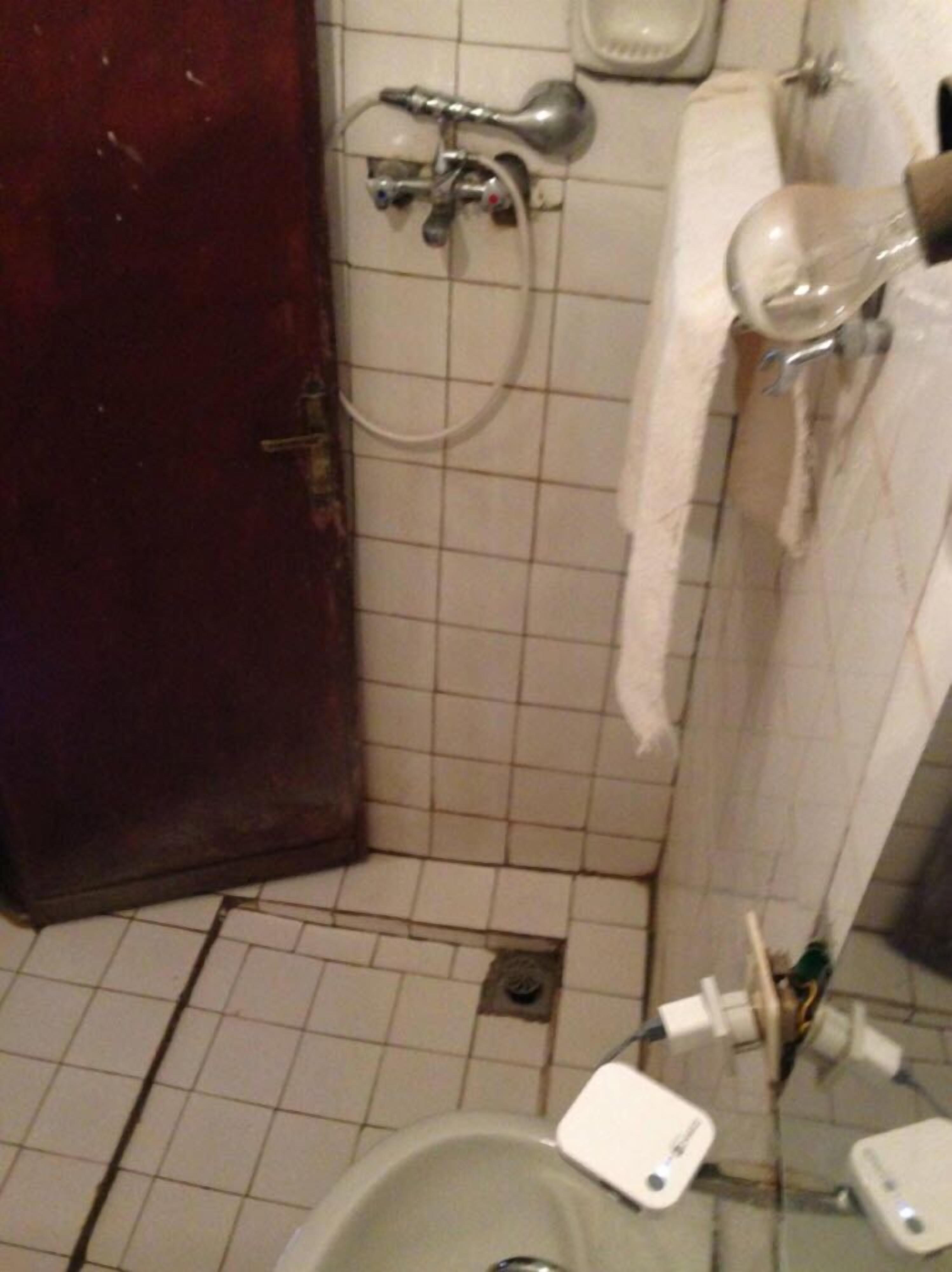 Un baño pequeño con inodoro, ducha y lavamanos.