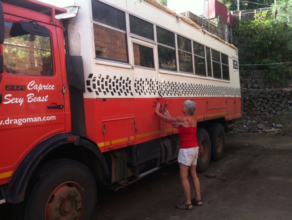 Un autobus rouge et blanc sur lequel on peut lire les inscriptions « Caprice Sexy Beast » et « www.dragoman.com » sur le côté.