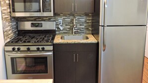 A compact kitchen with a microwave, stove, oven, sink, and refrigerator. - Seabreeze Beachside Studios by ValGal (Hollywood)