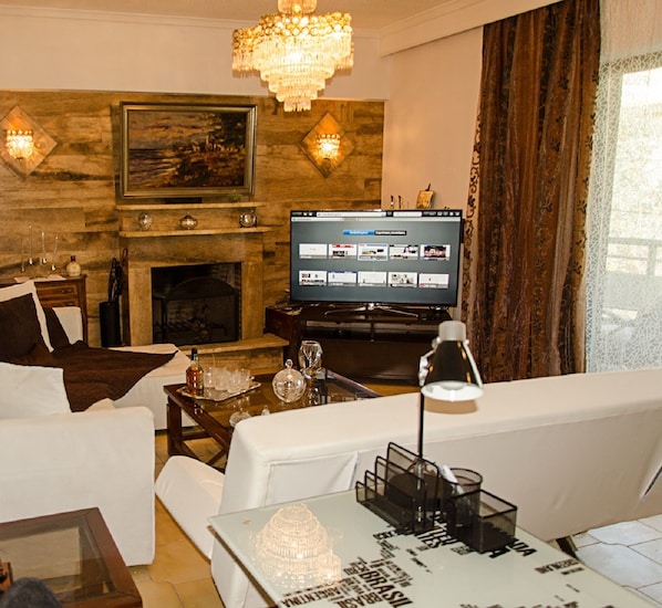 Departamento Deluxe, 2 habitaciones | Área de sala de estar | Smart TV de 50 pulgadas con canales vía satélite, televisión y chimenea