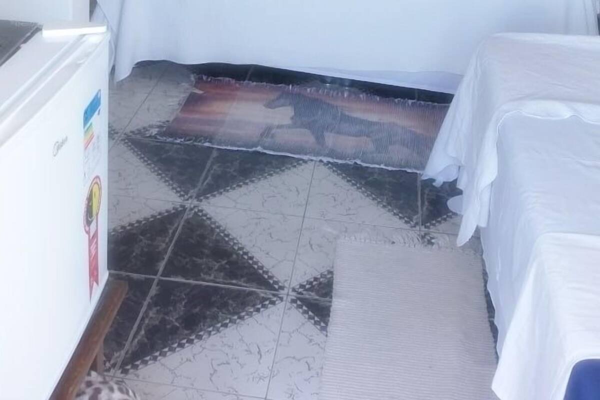 Un dormitorio con cama, ventilador de techo, un cuadro en la pared y suelo de baldosas.