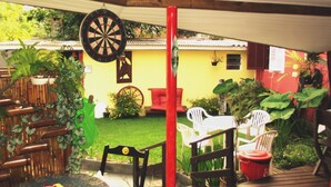 A patio area with a dartboard, outdoor furniture, and potted plants. - Pousada Tonapraia (Florianópolis)