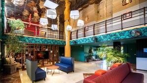 A spacious lobby with a high ceiling, multiple seating areas, and a large plant in the center. - Best Western La Marina (Saint-Raphael)
