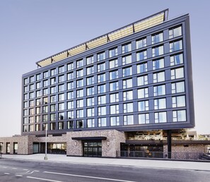 Un edificio moderno con una fachada de ladrillo, un techo plano y una cuadrícula de ventanas.