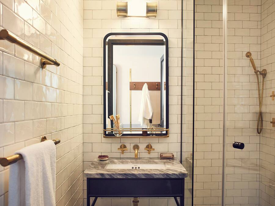 A bathroom with a marble sink, a mirror, and a shower with a glass door.