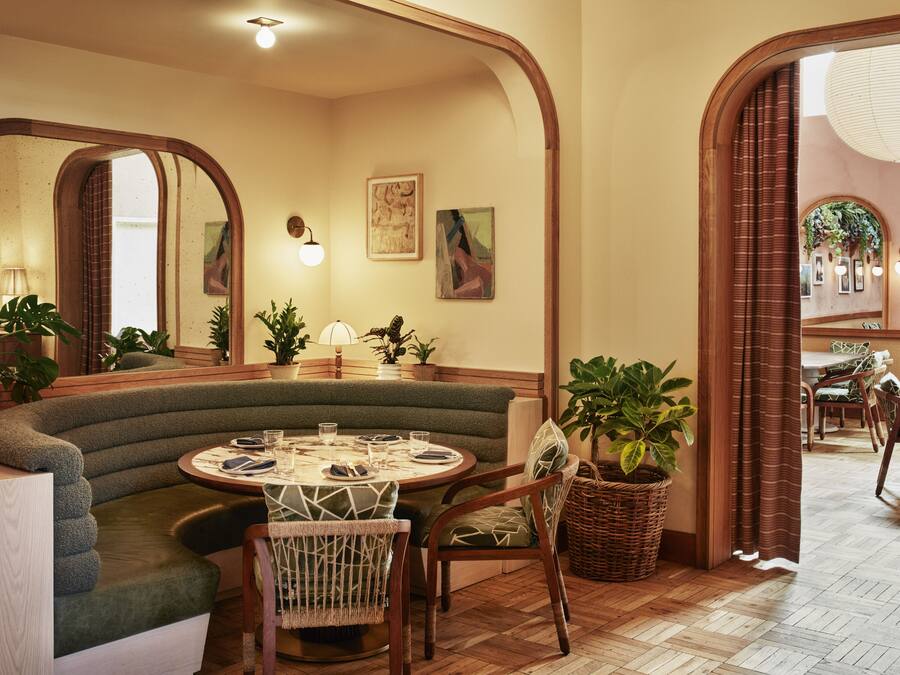 Un coin repas accueillant avec une table ronde, des sièges confortables et des plantes en pot.