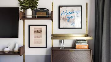 A wall with a framed picture saying "Missing you," a plant, a vintage radio, and a shelf with books and a small vase.