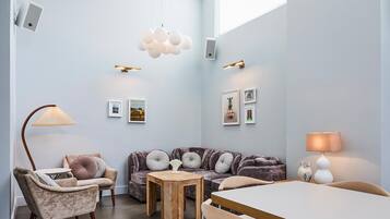 A modern living room with a sofa, chairs, a coffee table, and a dining table.