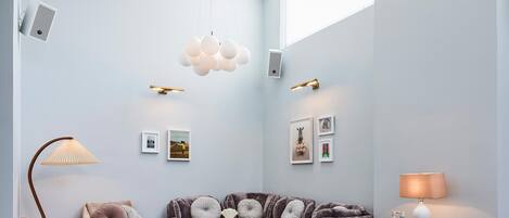 A modern living room with a sofa, chairs, a coffee table, and a dining table.