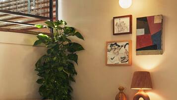 A cozy dining area with a round table, patterned chairs, a potted plant, and wall art.