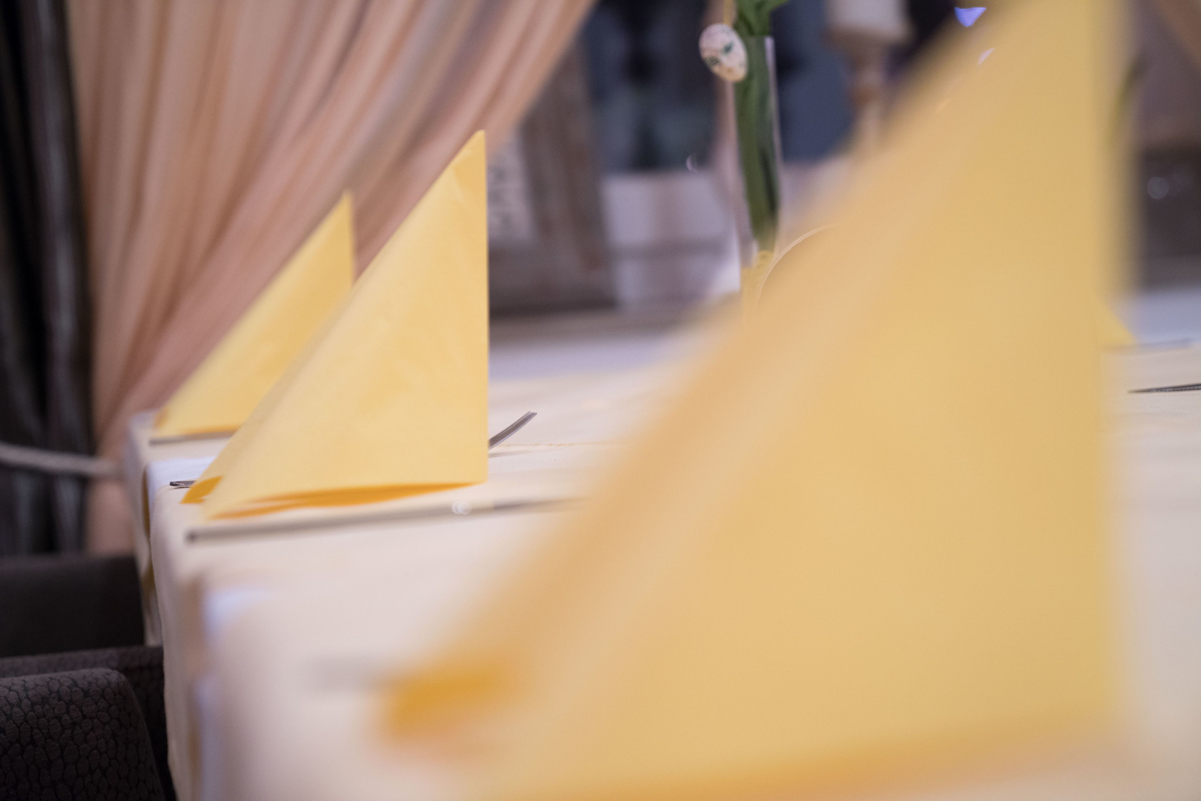 Gelbe, dreieckige Dekorationen auf einem Tisch, möglicherweise für eine besondere Veranstaltung.