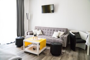 Deluxe Quadruple Room, Multiple Beds, Balcony (Yellow /Grey Nr 1) | Living area | 105-cm flat-screen TV with cable channels, TV, books - Pension & Restaurant La Amalia (Bad Sauerbrunn)