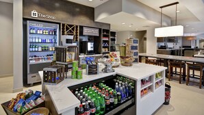 A modern retail area with a chilled beverage display, snack shelves, and a coffee station. - Hilton Garden Inn Gastonia (Gastonia)