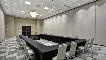 A conference room with a long table, chairs, and a chandelier.