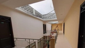 A spacious corridor with a skylight, a staircase, and a railing. - Hotel El Andino (San José de Cúcuta)