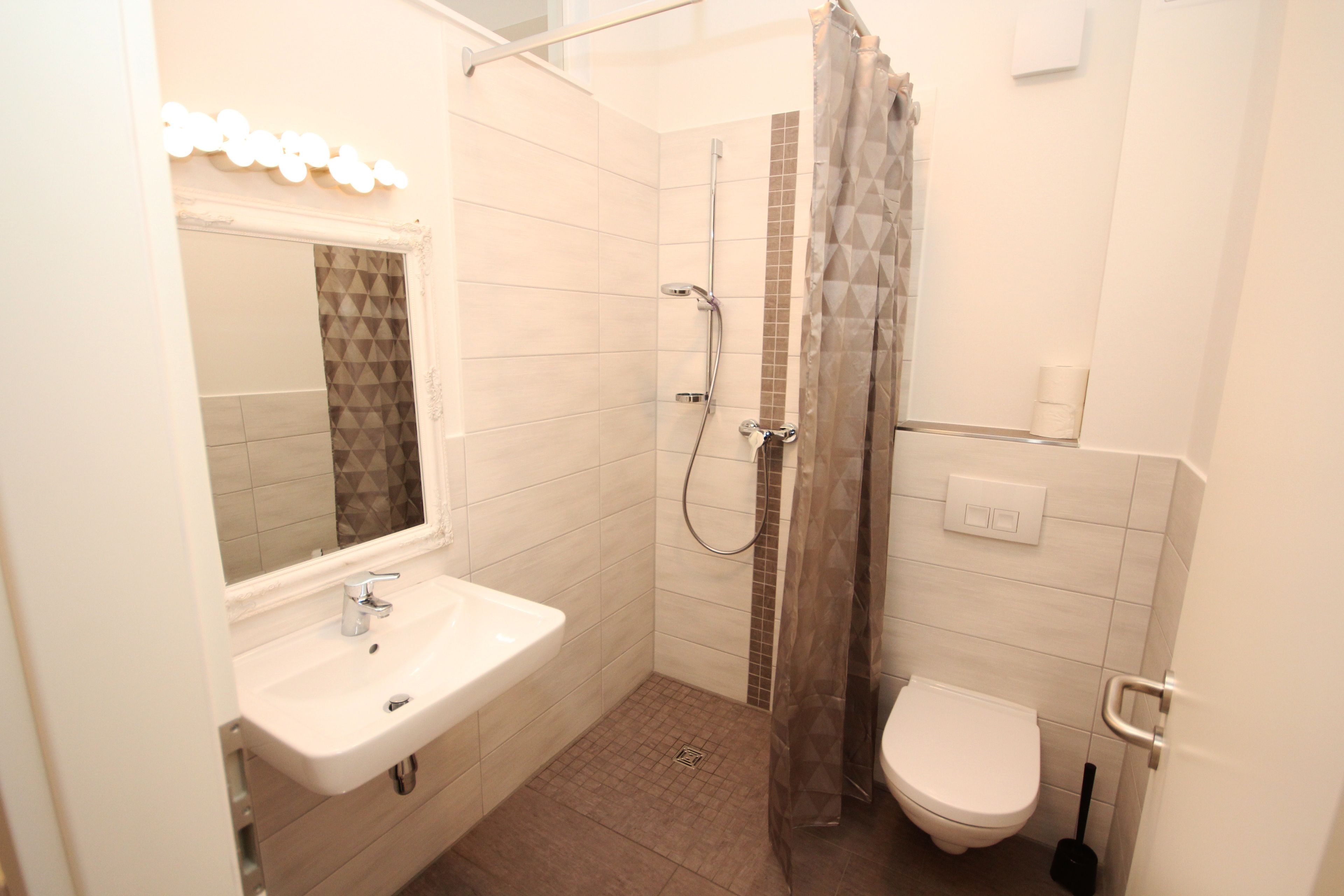 Un baño moderno con ducha, inodoro y lavamanos.