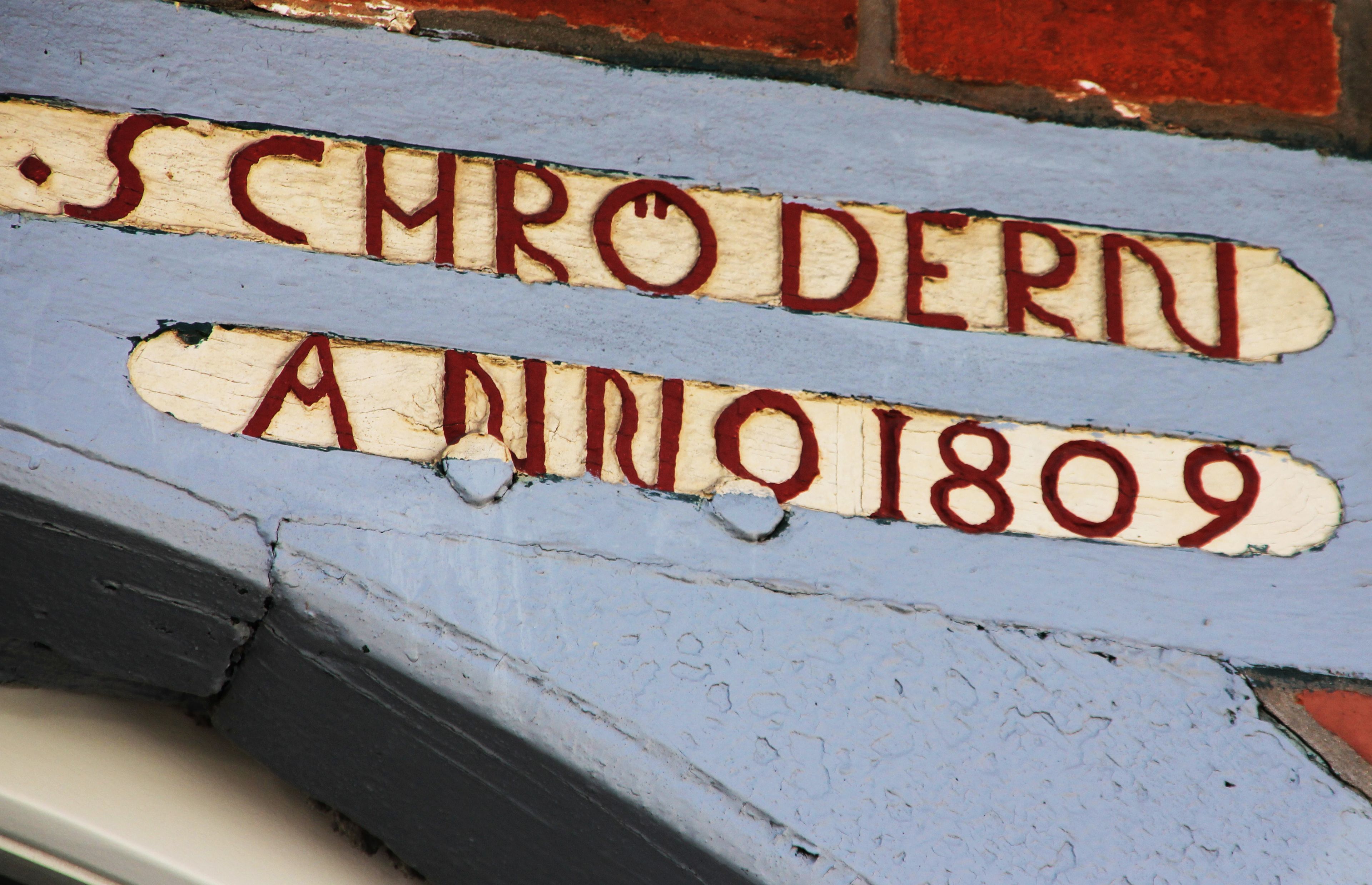A wall with the text "SCHRODERN A 1809" painted on it.