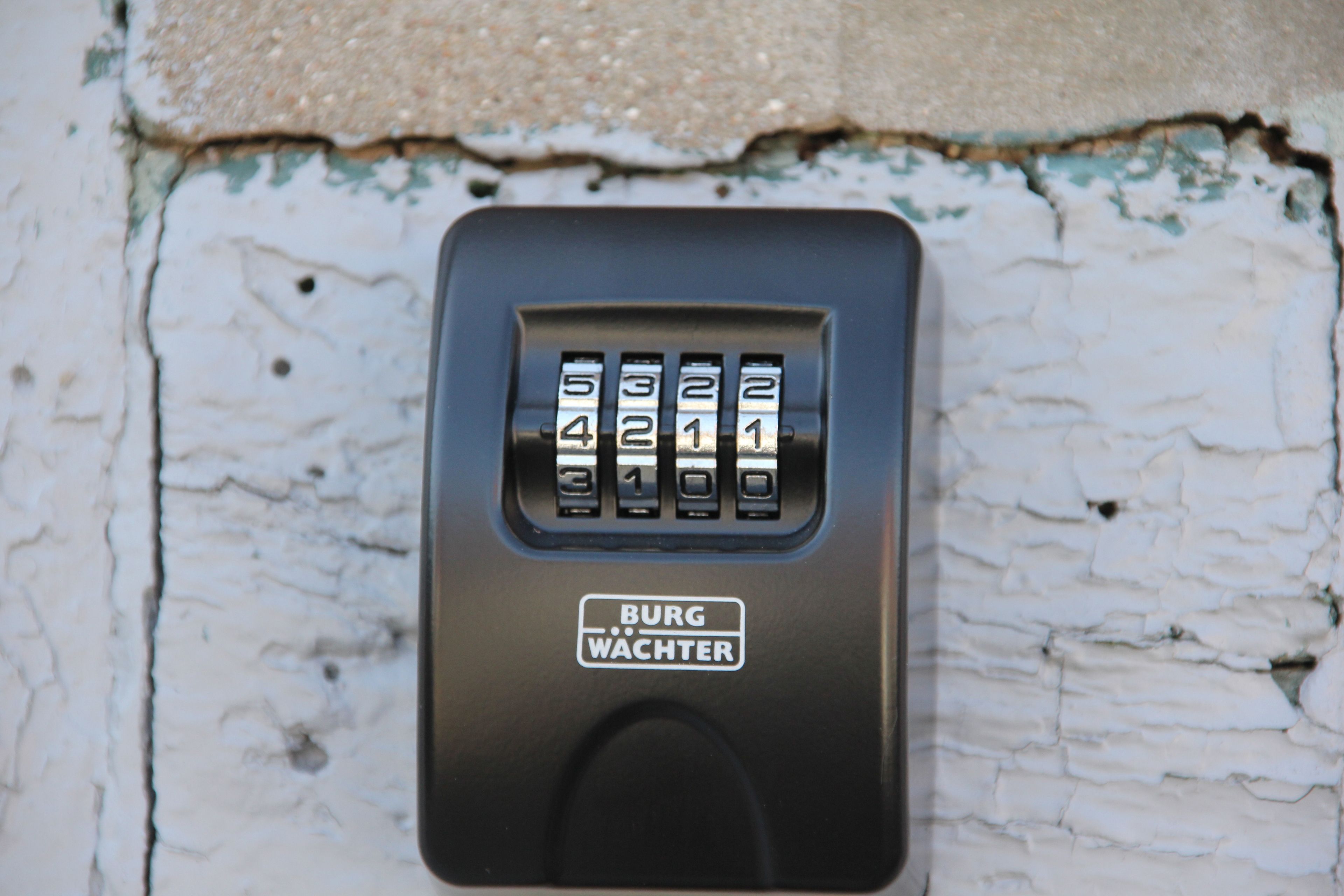 A keypad with the inscription "BURG WACHTER" on a textured wall.
