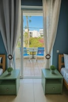 A room with a balcony, a bed, a nightstand with a plant, and a chair.