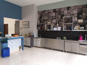 A modern kitchen with a black and white patterned backsplash, a blue accent wall, and a counter with various items. - Rethymno Blue Residence (Rethymno)