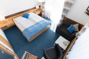 Ein Hotelzimmer mit einem Bett, einer Couch, einem kleinen Tisch und einem Sessel.