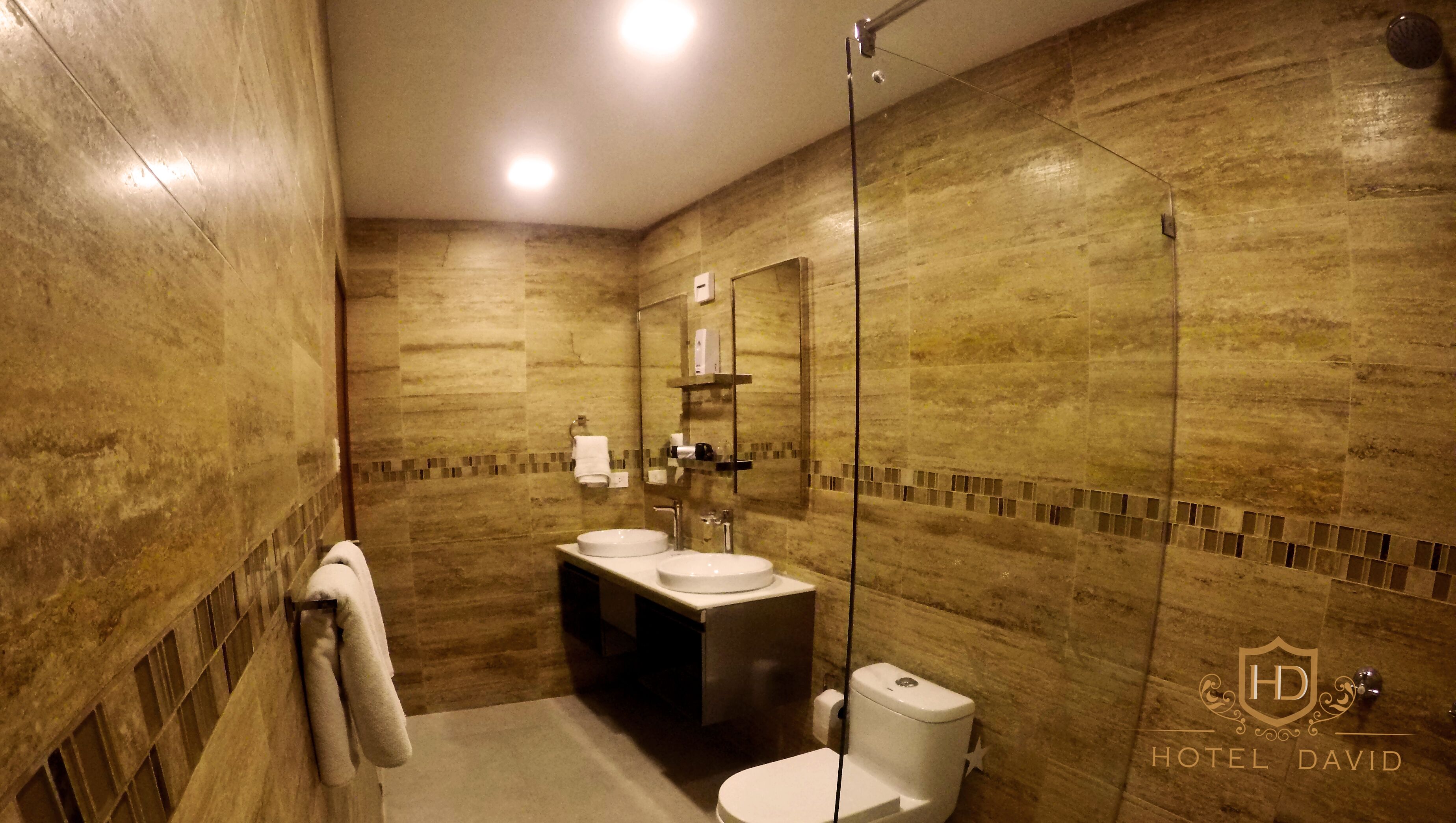 Un baño con cabina de ducha de vidrio, un lavabo e inodoro.