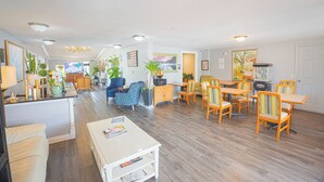 A spacious living area with a dining table, chairs, a sofa, and a TV. - Liberty Inn And Suites Orlando - Kissimmee Near Disney World (Kissimmee)