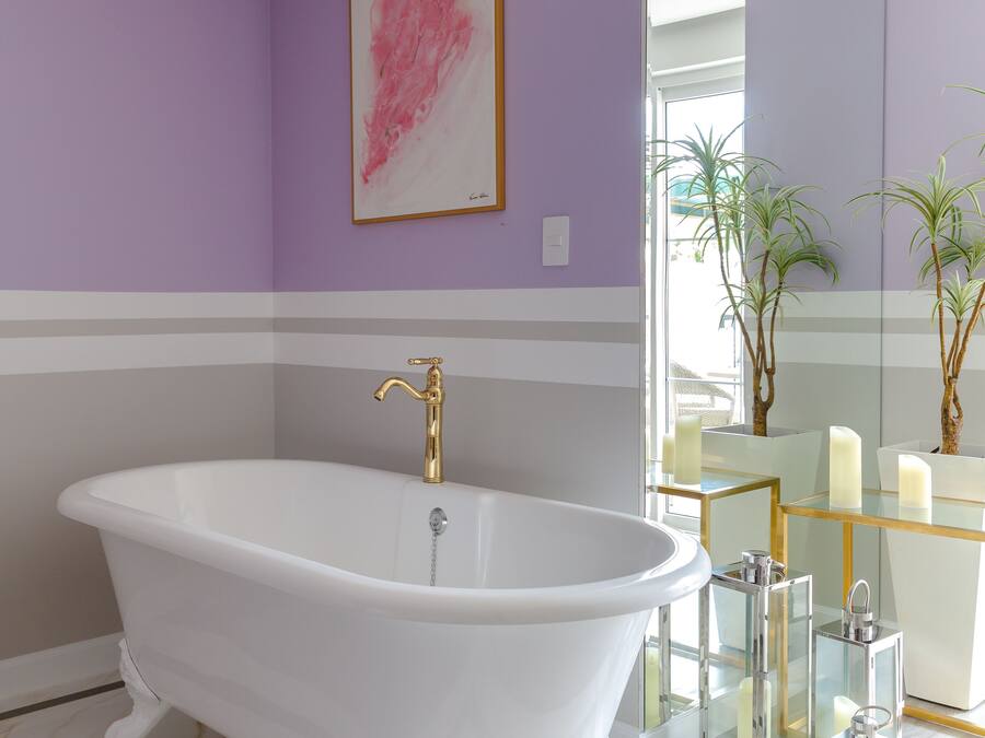 A modern bathroom with a freestanding bathtub, a large mirror, and a glass vanity.