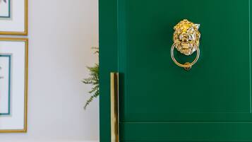 Una puerta verde con un tirador dorado con forma de cabeza de león.