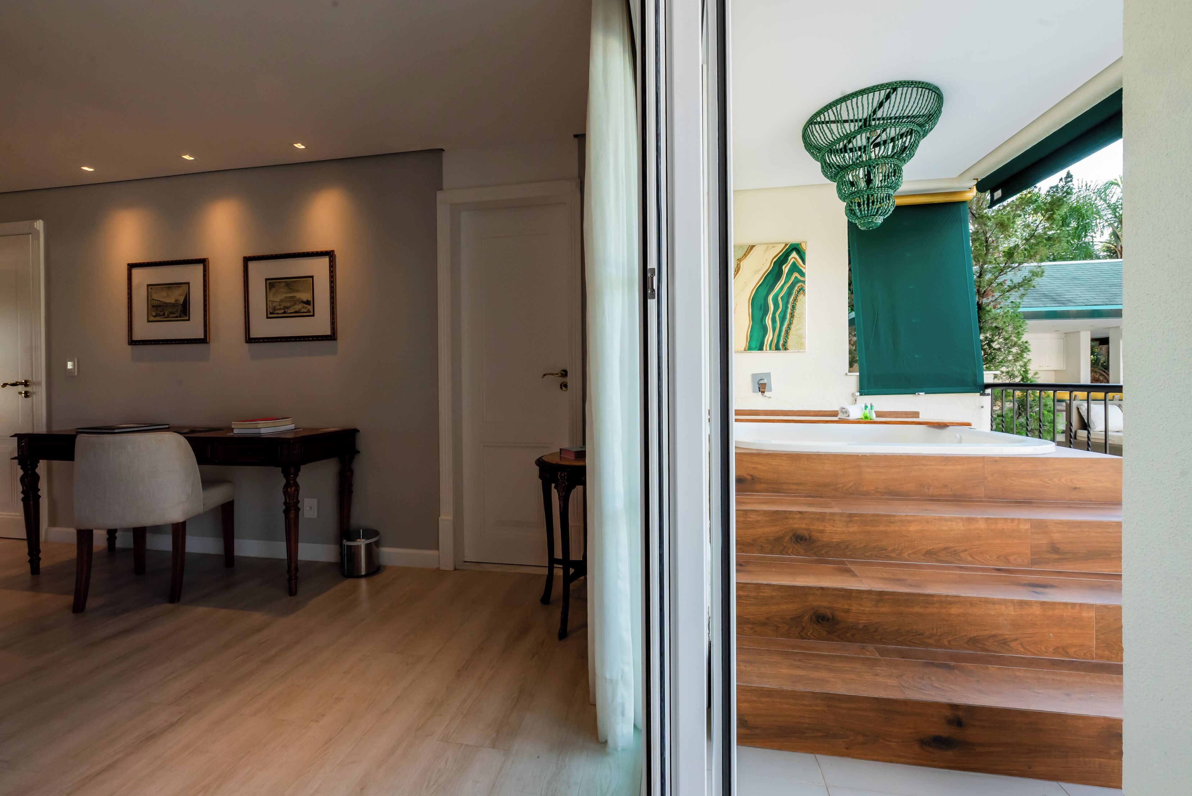 A modern interior with a wooden staircase, a dining area with a table and chairs, and a view of the outside.