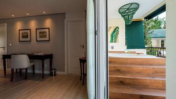 A modern interior with a wooden staircase, a dining area with a table and chairs, and a view of the outside.