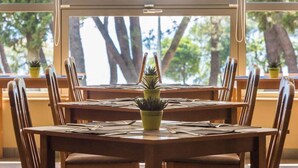 A dining area with a round table, chairs, and potted plants.