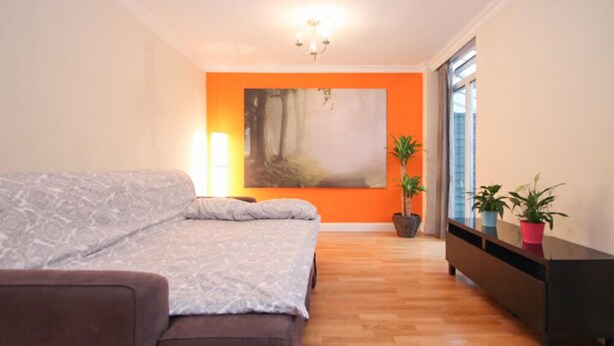 Ein modernes Schlafzimmer mit einem großen Bett, einem Bild an der Wand und einem Fenster mit Blick.