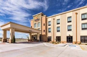 Un hotel Comfort Suites con entrada cubierta, varias ventanas y un estacionamiento que incluye un espacio para discapacitados.