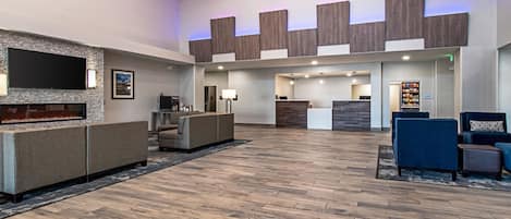A spacious lobby with a fireplace, seating area, and a reception desk.